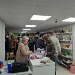 Interior shot of our Bury St Edmunds shop, showing customers buying goods at till, while others browse bric-a-brac shelves